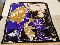 Purple, gold, black, and white floral silk scarf branded Marquis