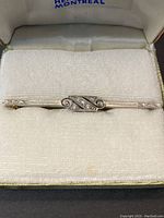 Front view of the bar brooch seated in its presentation box