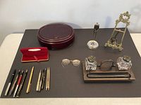 Overview showing pens, pencils, boxes, inkwells, stand, easel and eyeglasses