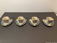 Four Rosenthal Dorothy Hafner espresso cups on triangular saucers in geometric pastel design.