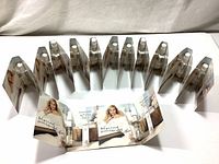 Fourteen 1.5ml mini perfume spray bottles arranged upright around a foldout promotional card for Elizabeth Arden White Tea Eau de Toilette.