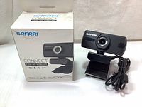 Photo showing the Safari Connect 720p HD webcam placed next to its original retail box with visible brand and model information.
