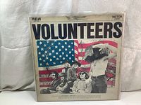 Front view of the Jefferson Airplane "Volunteers" LP album cover with band in front of American flag.