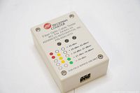 Top view of Beckman Coulter fiber optic cable tester showing LED indicators, brand logo, and labeled signal strength levels.