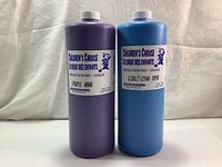 Two 1L bottles of Children's Choice Tempera Poster Paint in Purple and Cobalt/Cyan, showing full bottles and label information.