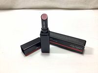 Photo of the Shiseido Color Gel Lip Balm, shade 109 Wisteria Sheer Berry, opened to show the lipstick color and black packaging with brand name visible.
