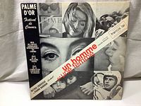 Front of the LP album cover showing black and white photo collage with text including Palme d'Or Cannes Festival and album credit details.