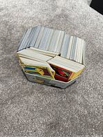 Top-down view showing a tin filled with numerous Pokémon cards packed tightly, some cards visibly displaying Pokémon art and card borders.