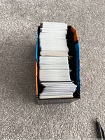 Top view of an open Pokémon Elite Trainer Box filled with multiple stacks of Pokémon trading cards.