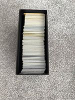Top view of a black Pokémon ETB box filled with a large stack of Pokémon cards packed inside.