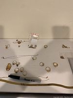 Full lot shot on white surface showing multiple rings and chains arranged around a Sharpie marker