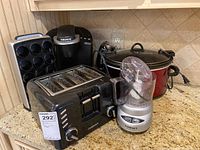 Kitchen counter with all six appliances and accessories: food processor, toaster, coffee maker, slow cooker, can opener, and pod holder
