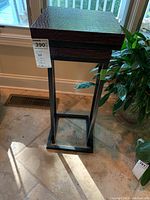 Full view of stacked contemporary nesting tables showing brown faux alligator skin patterned tops and black metal frames, with tags visible.