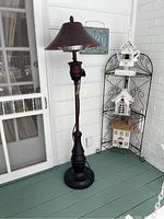Full view of electric outdoor heater standing on porch near door.
