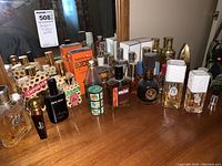 View of all perfume and cologne bottles arranged on a wooden dresser with mirror