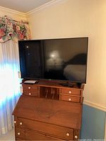 Front view of Vizio 43-inch LCD TV on wooden cabinet showing screen and remote on cabinet.