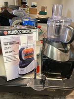 Black & Decker food processor with its box and some attachments displayed on a surface