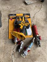 Image showing the packaged WorkForce 3-piece aviation snip set, Dewalt cordless drill without battery, and three mechanical gauges on a concrete floor.