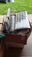 Large box with black plastic trays filled with rock wool starter plugs wrapped in plastic, alongside flexible silver metallic air vent connectors.