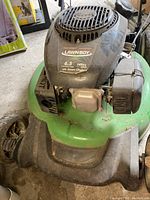 Front view of green steel deck and black engine cover showing Lawnboy branding and 6.5 ft-lbs/148cc label