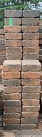 Front view of two stacked rows of weathered heavy rectangular patio stones, majority measuring about 8 x 7 x 2 3/4 inches.