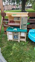 Front view of the plastic play kitchen showing stove, sink, oven, microwave, and refrigerator sections.