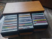 Top-down view showing 39 CDs arranged in three compartments of the wooden holder case.