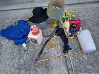 Full overview of lot items arranged on ground showing nutcracker, clothing, accessories, lamp, ruler, and other items