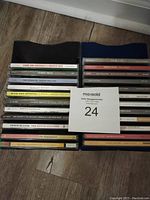 Photo showing the spines of 23 used music CDs stacked together