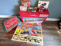 Full lot overview with boxed Dillard's Christmas Train, boxed Marx train, and Tyco slot car track boxes and parts