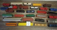 Top-down view of all 29 train cars showing assortment of tankers, flatcars, boxcars, and cabooses in various colors and brands.