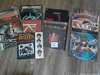 Photo of 21 vinyl records spread on floor showing Beatles, Ratt, Quiet Riot, Twisted Sister, and others