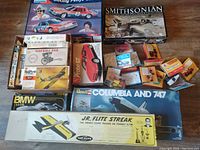 Photo of multiple boxed vintage model kits including cars and aircraft from different brands.