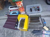 Overview photo showing multiple boxed train items, tracks, accessories, and some Christmas themed packaging tubes.