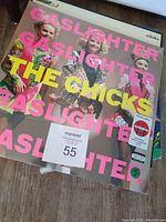 Photo of new sealed The Chicks 'Gaslighter' album with a pink cover featuring three women in colorful outfits, text in bright yellow and pink.