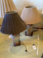 Full view of two Asian ceramic lamps side by side, one with dark brown shade and the other with beige shade.