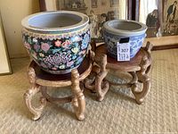 Both planters displayed on their respective wooden stands, showing relative sizes and finishes