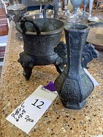Photo showing both cast iron bowl and bud vase next to each other on surface with sale tag