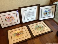 All five framed pieces arranged against wall and floor: four prints and one certificate.