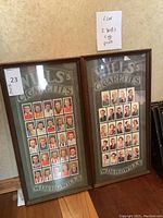 Full view of two matching framed Wills's Cigarettes advertisement prints showing multiple vintage cigarette cards of men portraying sportsmen or notable individuals.
