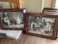 Two framed turn of the century art prints leaning side by side showing women and children scenes