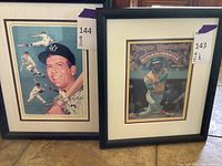 Photo showing two framed pieces of sports-themed art side by side, one of Mickey Mantle and one Sports Illustrated cover of Reggie Jackson.