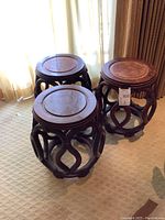 Three round rattan tables arranged together showing looped bases and wood tops