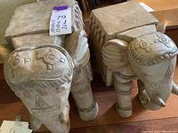Front view of two wooden elephant tables showing carved patterns and flat tops.