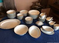 Entire Noritake Norwood 12 place setting displayed on table showing dinner plates, dessert plates, soup bowls, dessert bowls, tea cups with saucers, serving bowl, platter, gravy bowl, and sugar bowl.