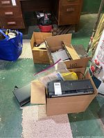 Multiple electronics in boxes on floor showing overall lot