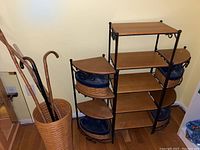 Front view of entire three-piece shelving setup with umbrella basket and canes at left
