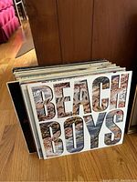Photo showing a stack of vinyl records with The Beach Boys album cover visible on front.
