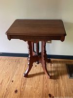 Front view of walnut side table showing carved apron and scalloped legs