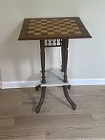 Full view of vintage chess game table showing wooden chess/checkerboard top and painted Victorian style legs with marble shelf.